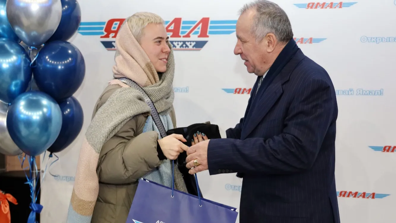 Татьяна Тазова получила подарок за то, что первой зарегистрировалась на рейс.  Фото: Василий Петров/ «Ямал-Медиа»
