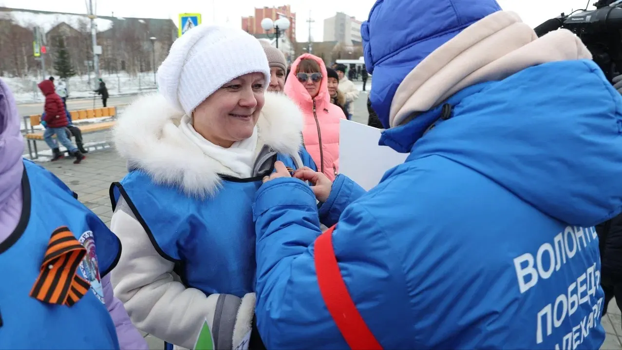На площади у Центра культуры и спорта «Геолог» волонтеры Победы раздают горожанам «георгиевские ленты». Фото: Андрей Ткачев / «Ямал-Медиа»